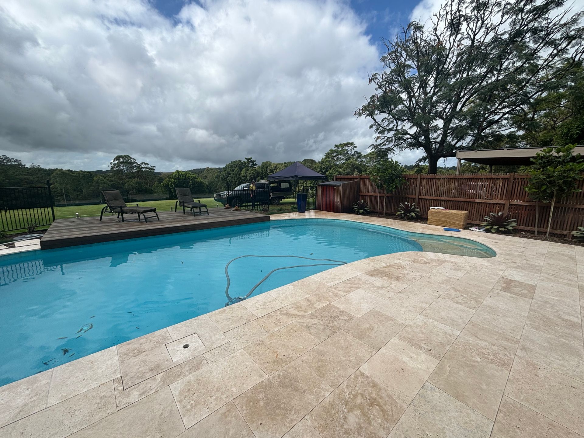 A pool with a small deck with chairs on it — Tim Williams Landscapes in Lennox Head, NSW