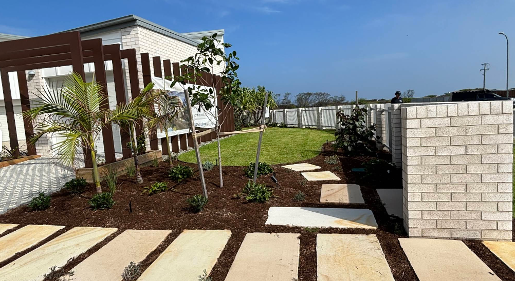 A back garden with stone and pebbles as well as medium sized trees — Tim Williams Landscapes in Wollongbar, NSW