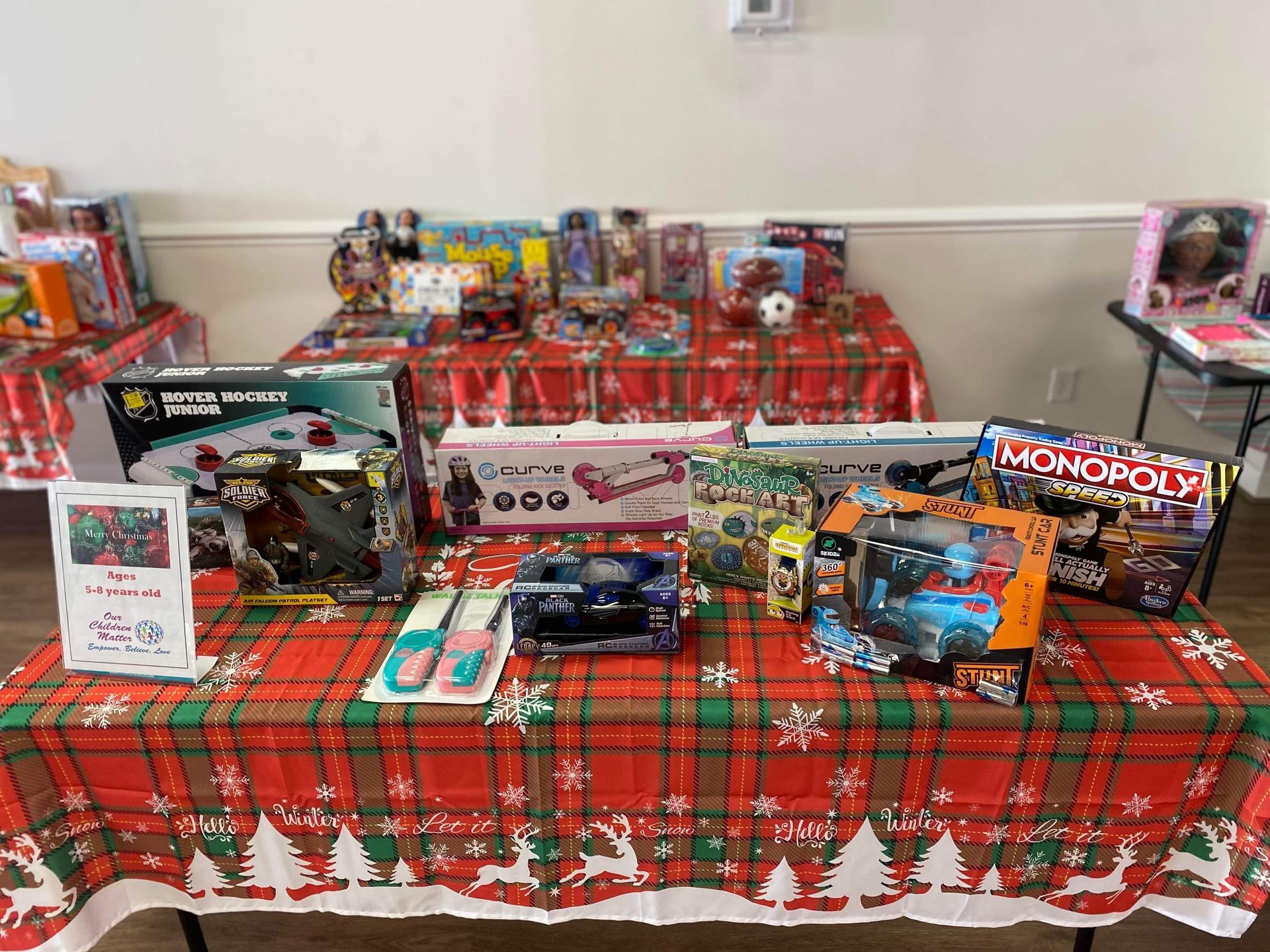 A table topped with lots of toys on a plaid tablecloth.