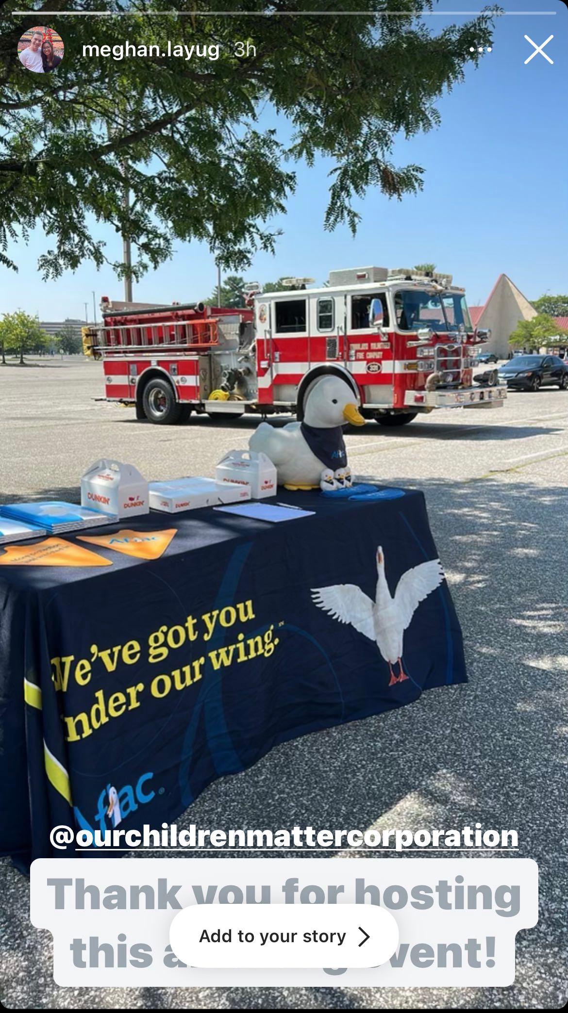 A fire truck is parked behind a table with a duck on it.