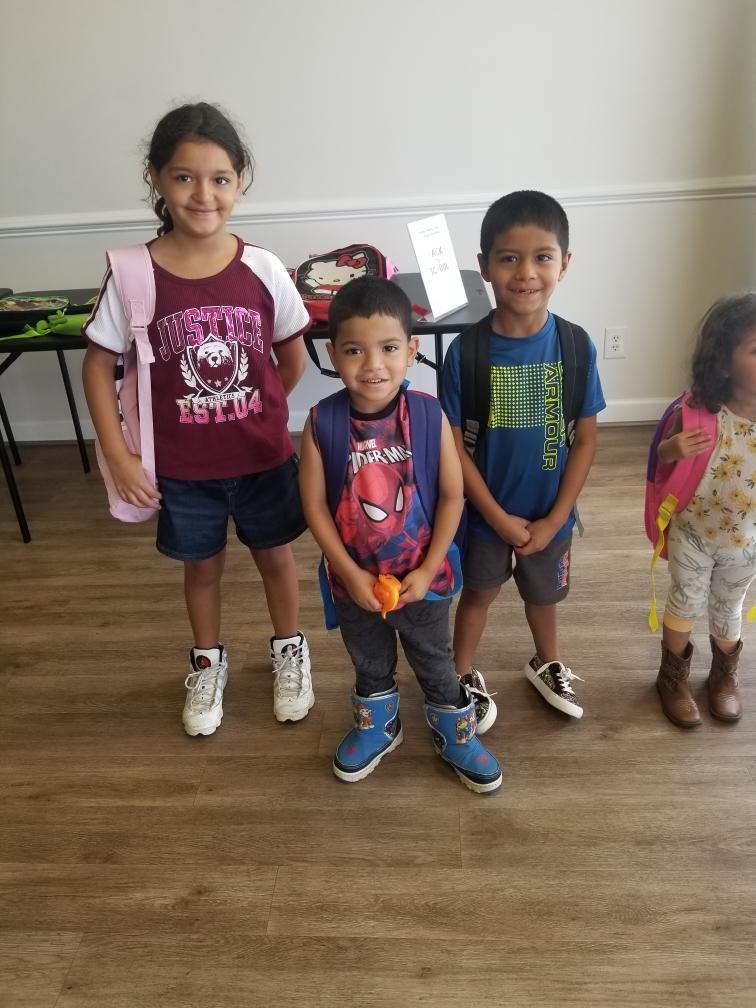 A group of children are standing next to each other in a room.