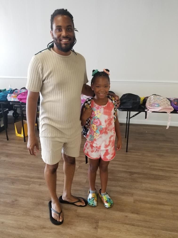 A man and a little girl are posing for a picture in a room.