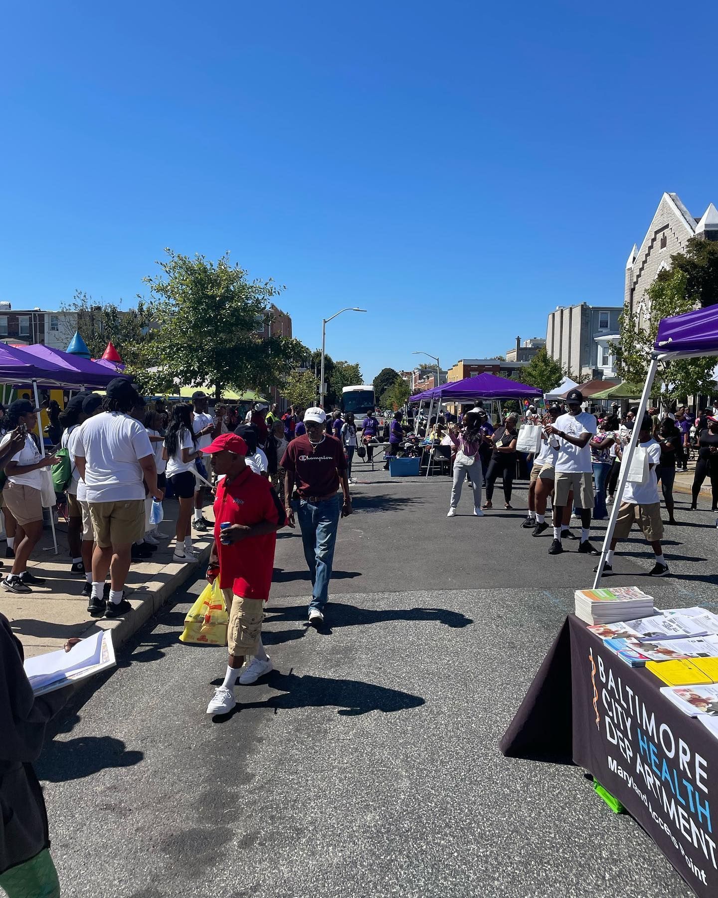 A crowd of people are walking down a street.