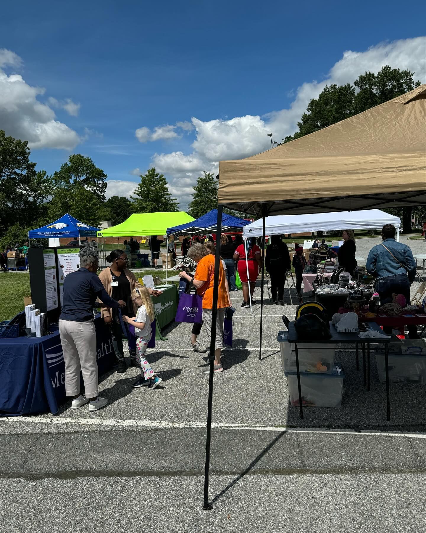 A group of people are standing under tents at a market.