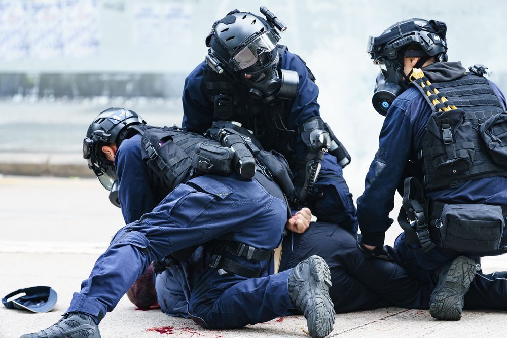 Image of police engaged in arrest in a 2020 Hong Kong protest (Photo: Sandra Sanders/Shutterstock)