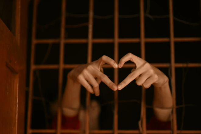 fingers forming heart hands from behind prison bars (Photo: Rajesh Rajput)