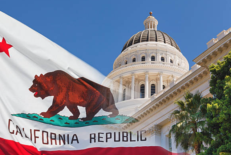 image of State of California capitol building in Sacramento next to the California state flag.