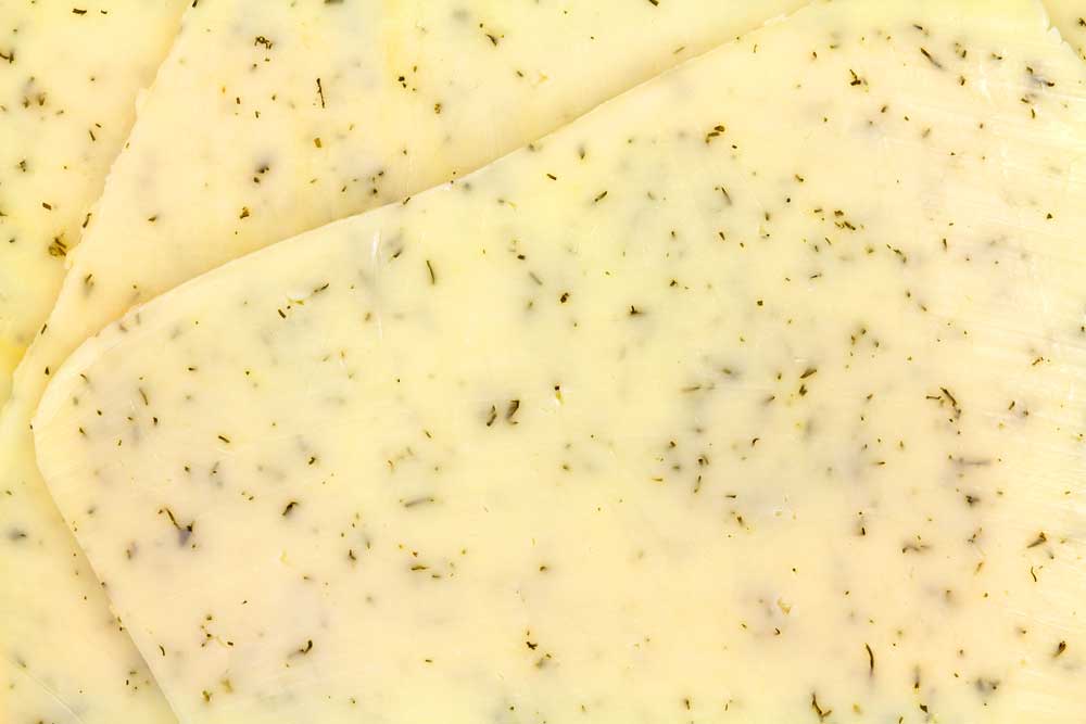 Close-view-of-several-slices-of-havarti-cheese-with-dill-seasoning