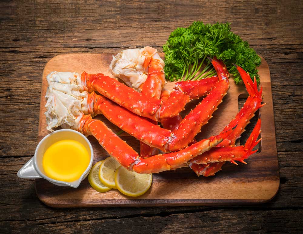 Cooked Organic Alaskan King Crab Legs with Butter and lemons