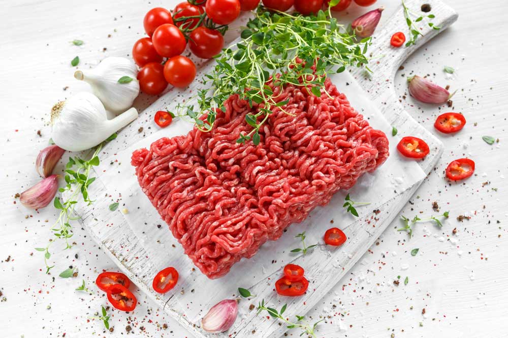 Fresh Raw Beef ground Meat with salt, pepper, chilli and fresh thyme
