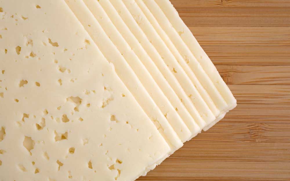 Havarti-cheese-slices-on-a-cutting-board