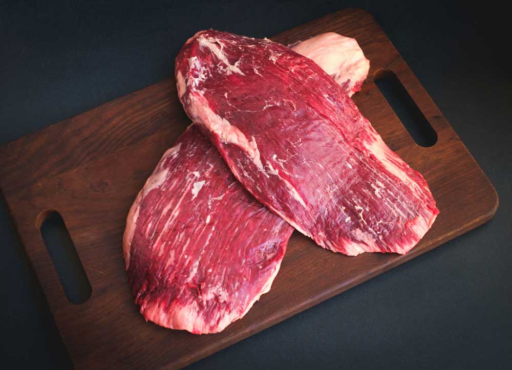 Raw flank beef on a wooden board