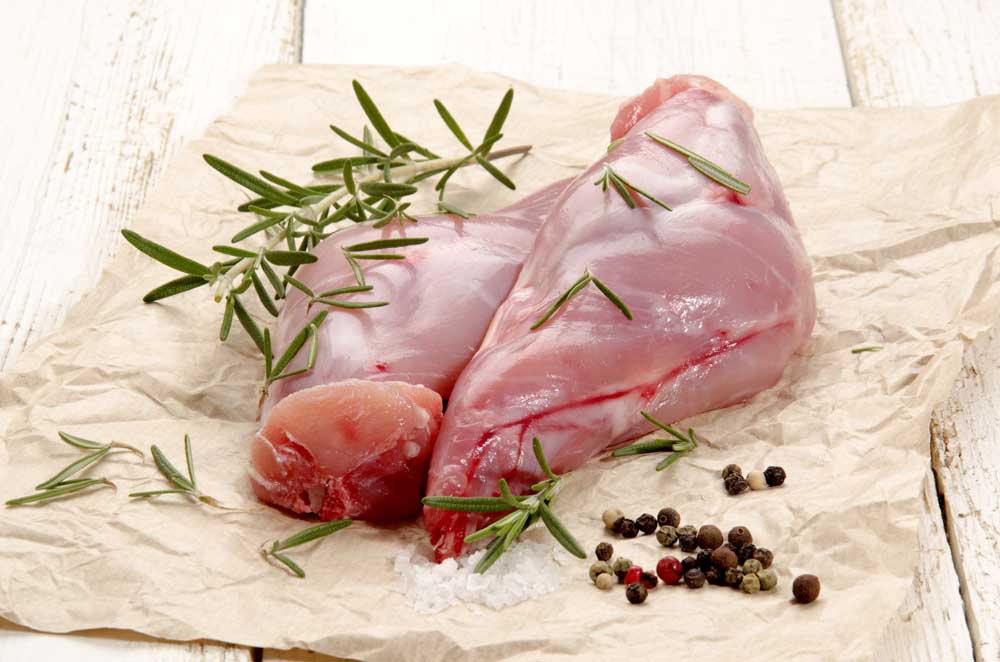 Raw rabbit leg on brown paper