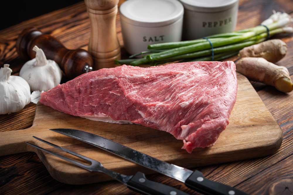 Raw tri tip steak beef on wooden cutting board