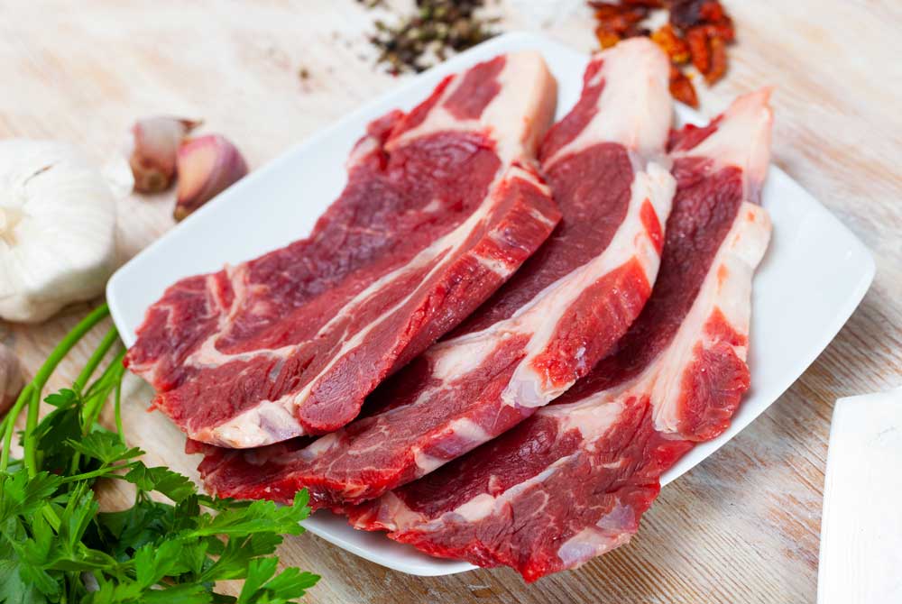 Sliced raw veal steak with fresh parsley
