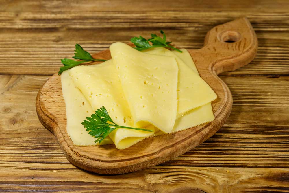 Slices-of-cheese-on-cutting-board