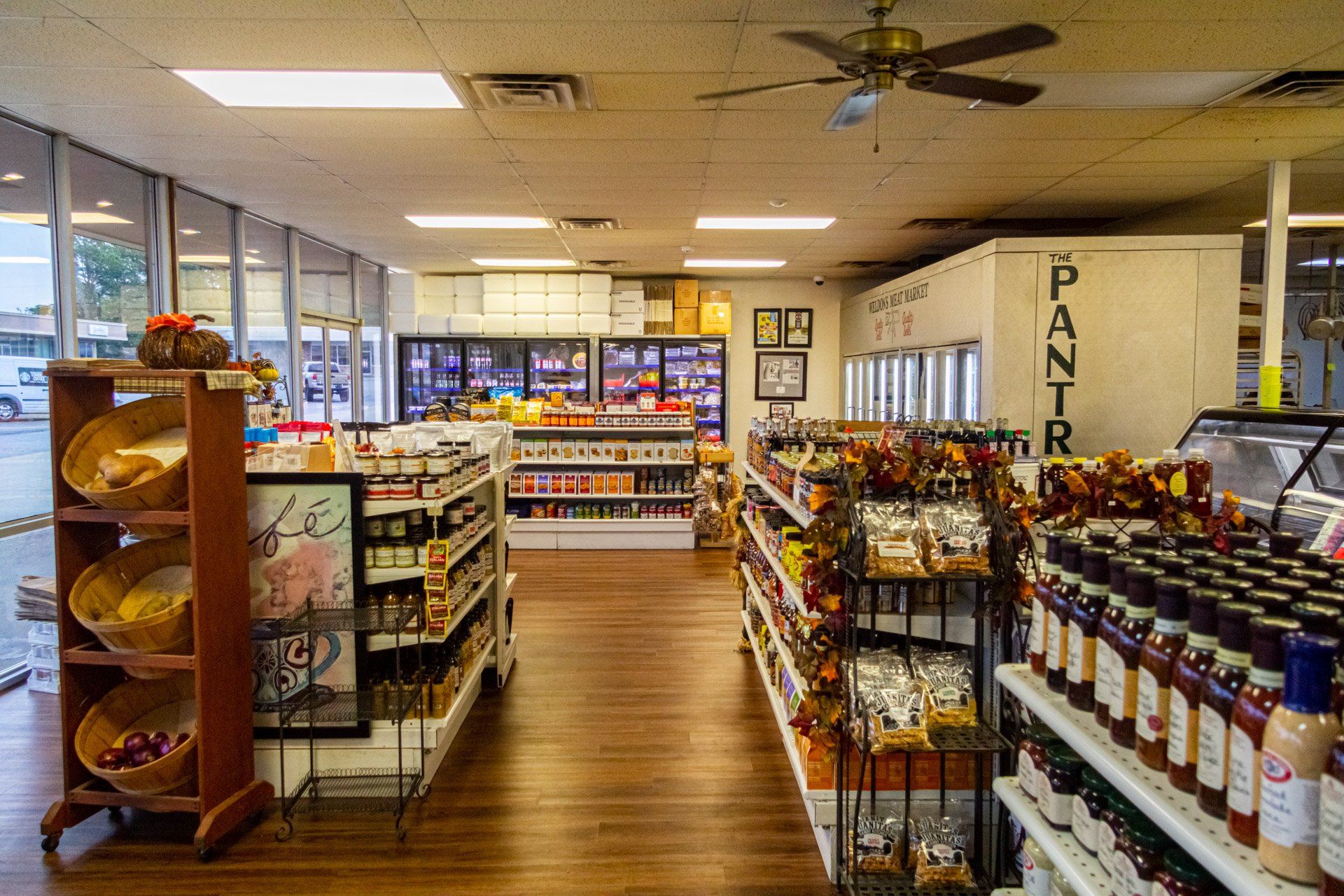A grocery store filled with lots of shelves and a ceiling fan.