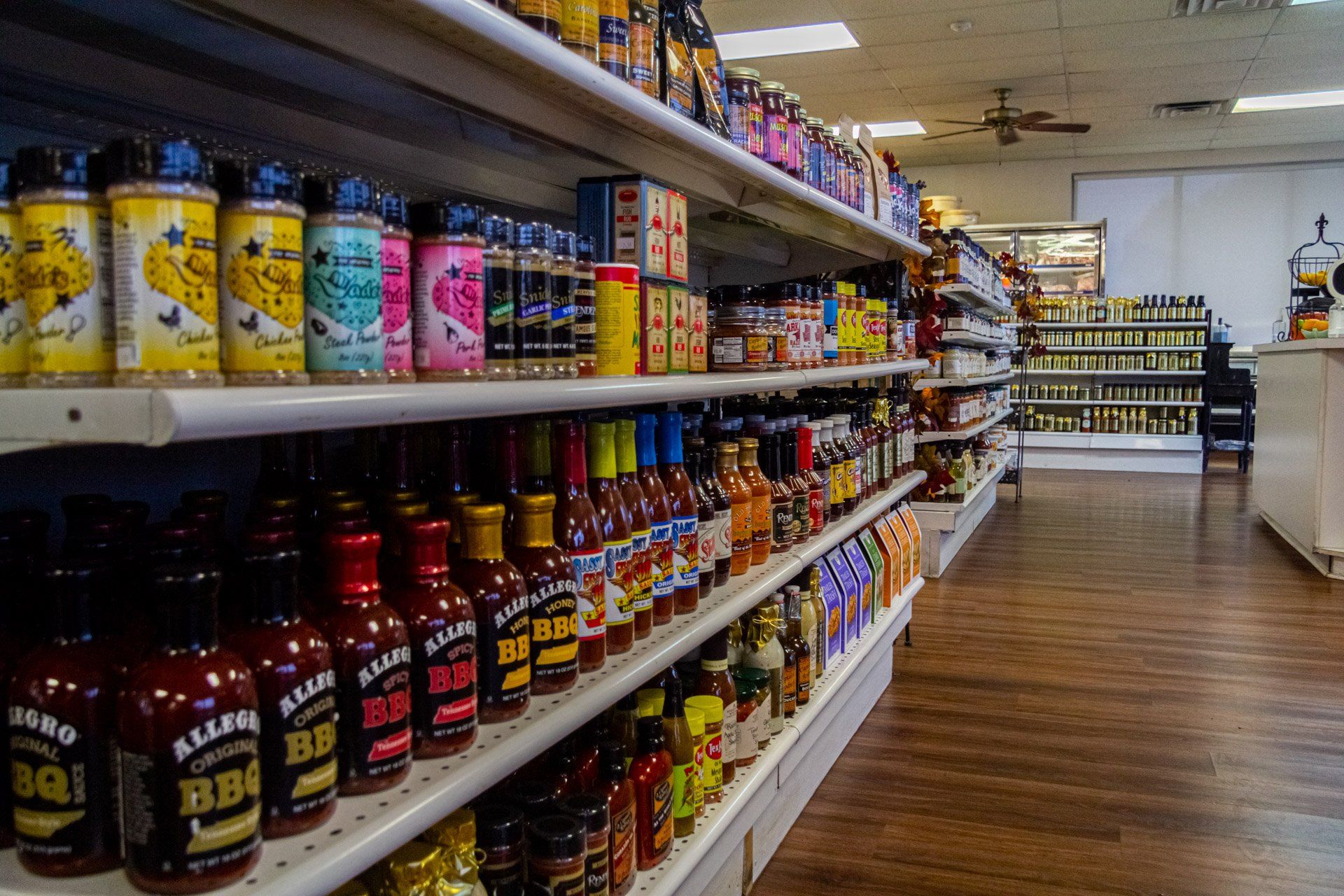 A grocery store aisle filled with lots of condiments and sauces.