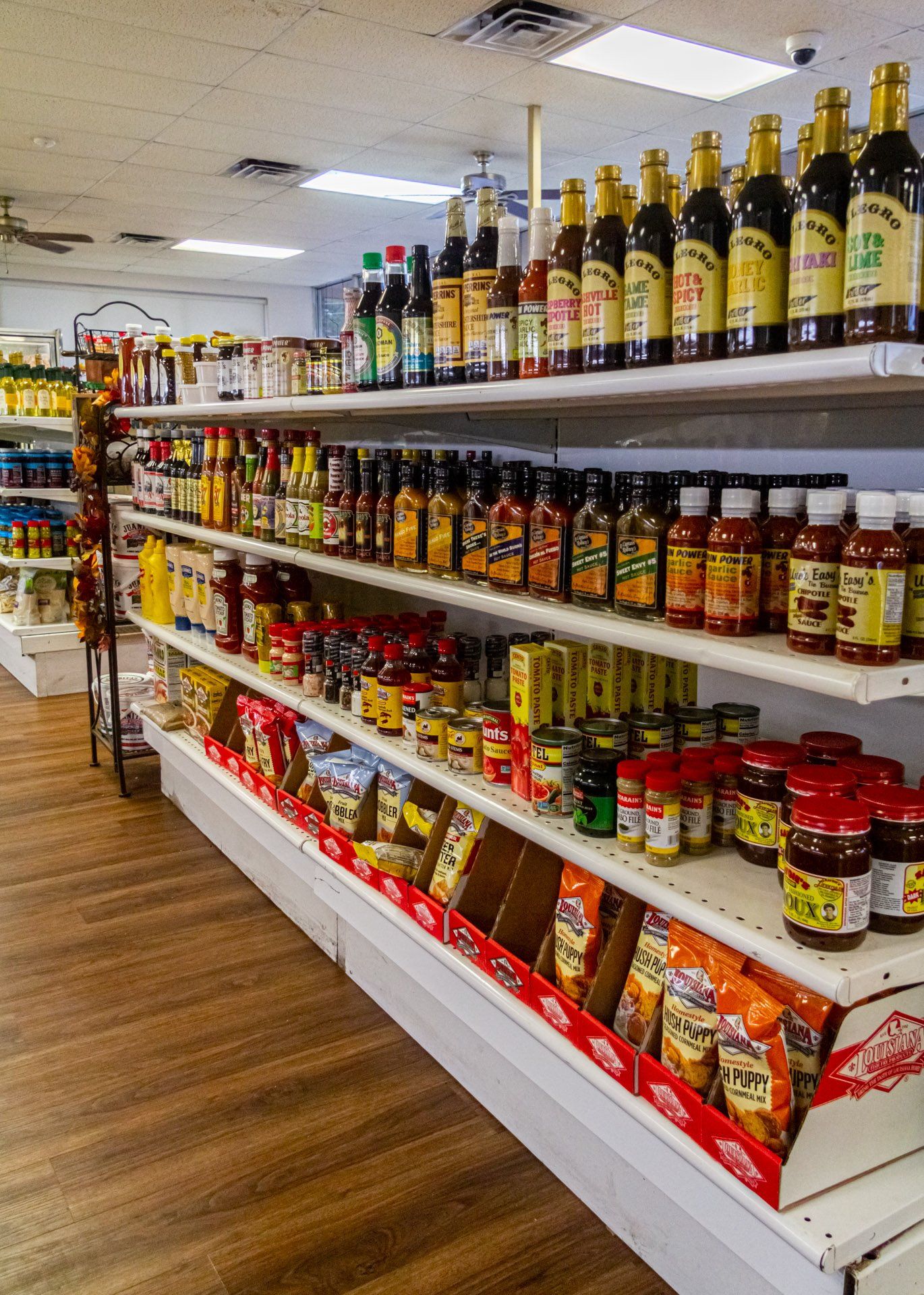 A grocery store aisle filled with lots of condiments and sauces.