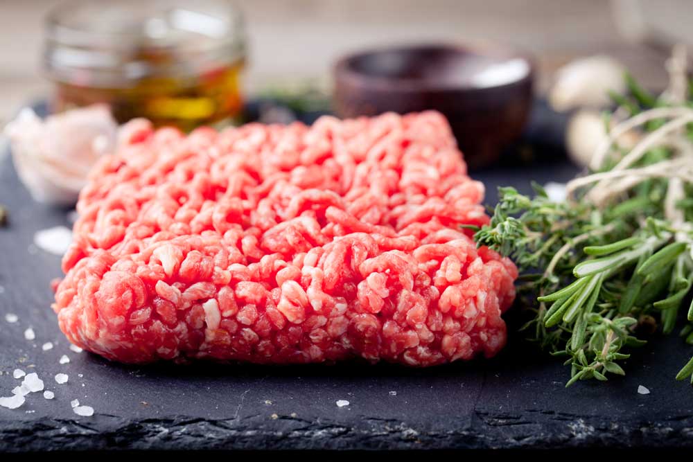 ground lamb meat on a slate stone black board