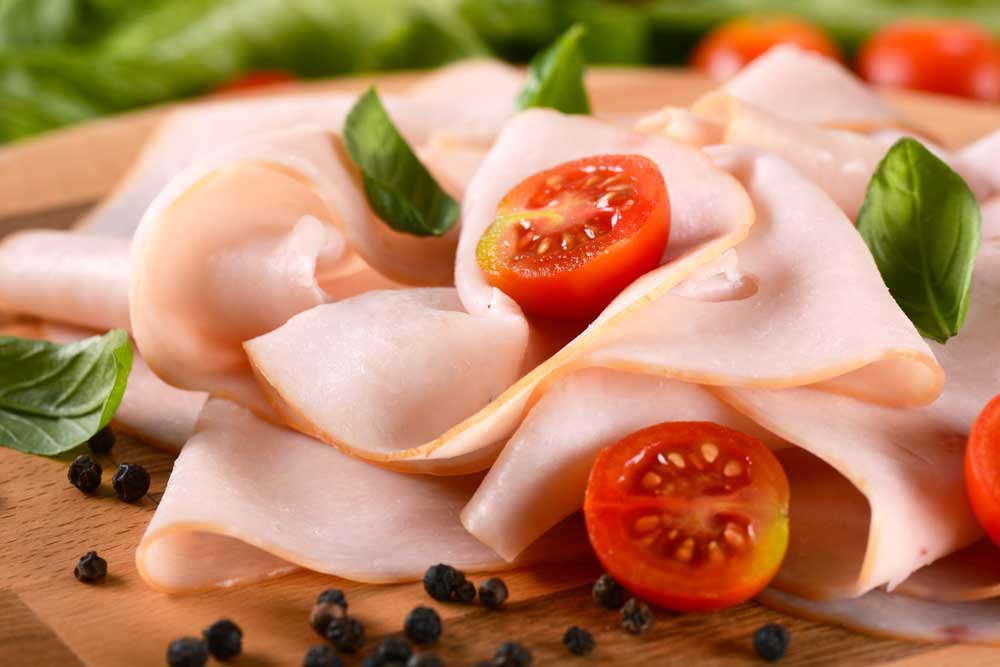 sliced turkey breast rolled up on the cutting board