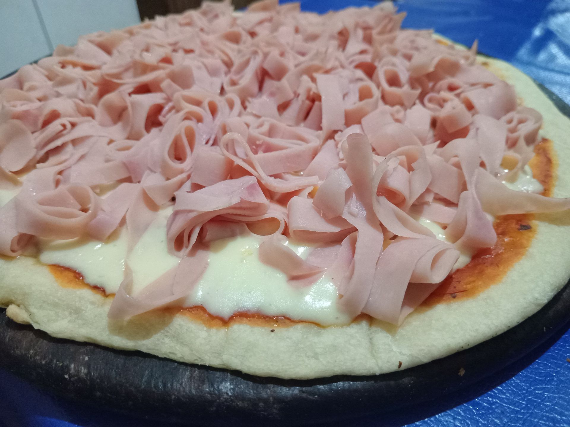 Una pizza con jamón y queso encima.