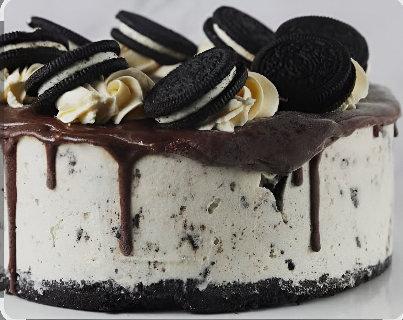 Un pastel blanco y negro con oreos encima.