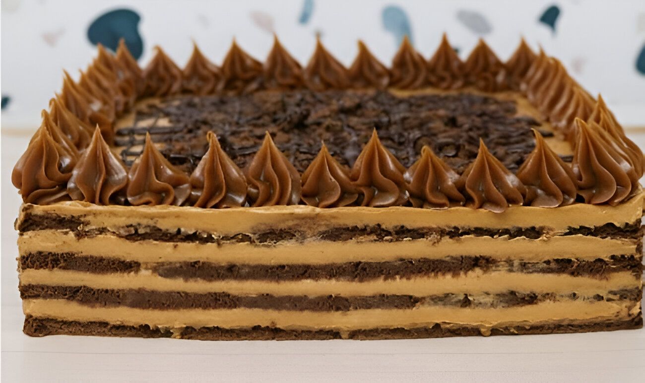Un pastel de chocolate con glaseado de caramelo está sobre una mesa.