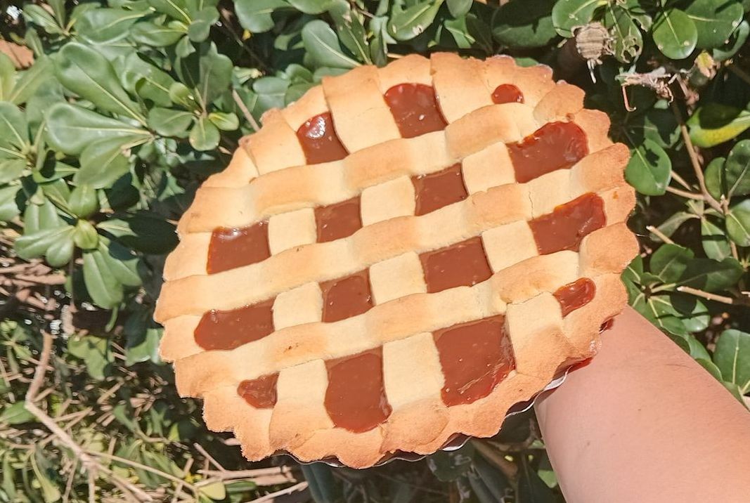Una persona sostiene un pastel en su mano.