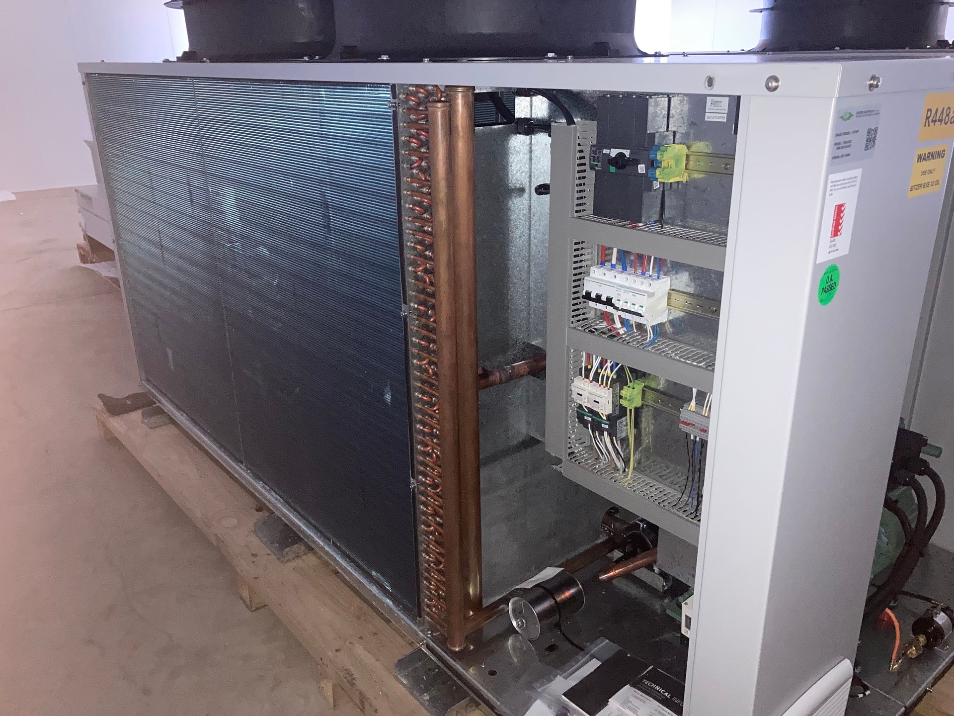 A Man Is Working On An Air Conditioner On A Balcony — Vertex Refrigeration & Air Conditioning Pty Ltd In Cannonvale, QLD