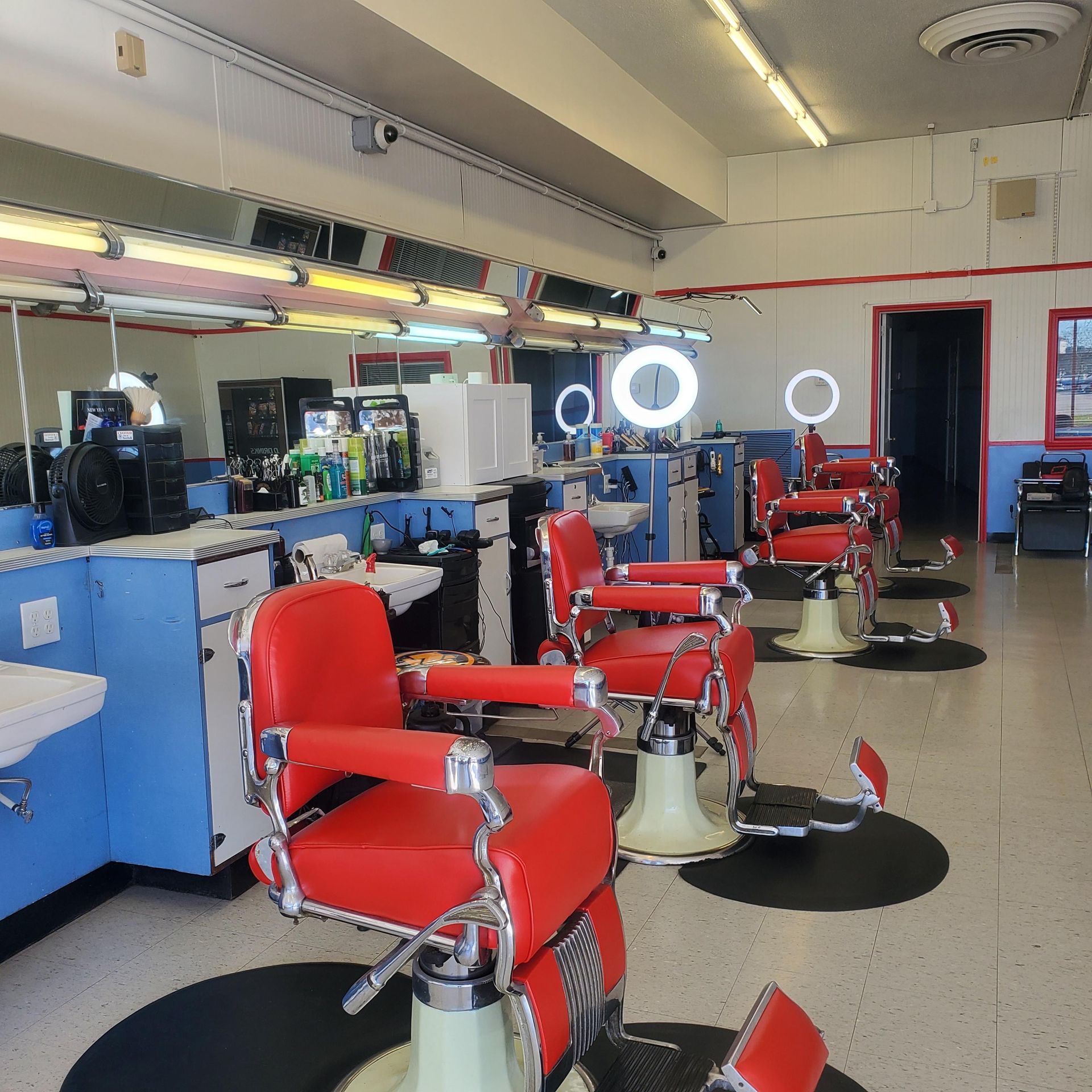A row of red barber chairs in a barber shop