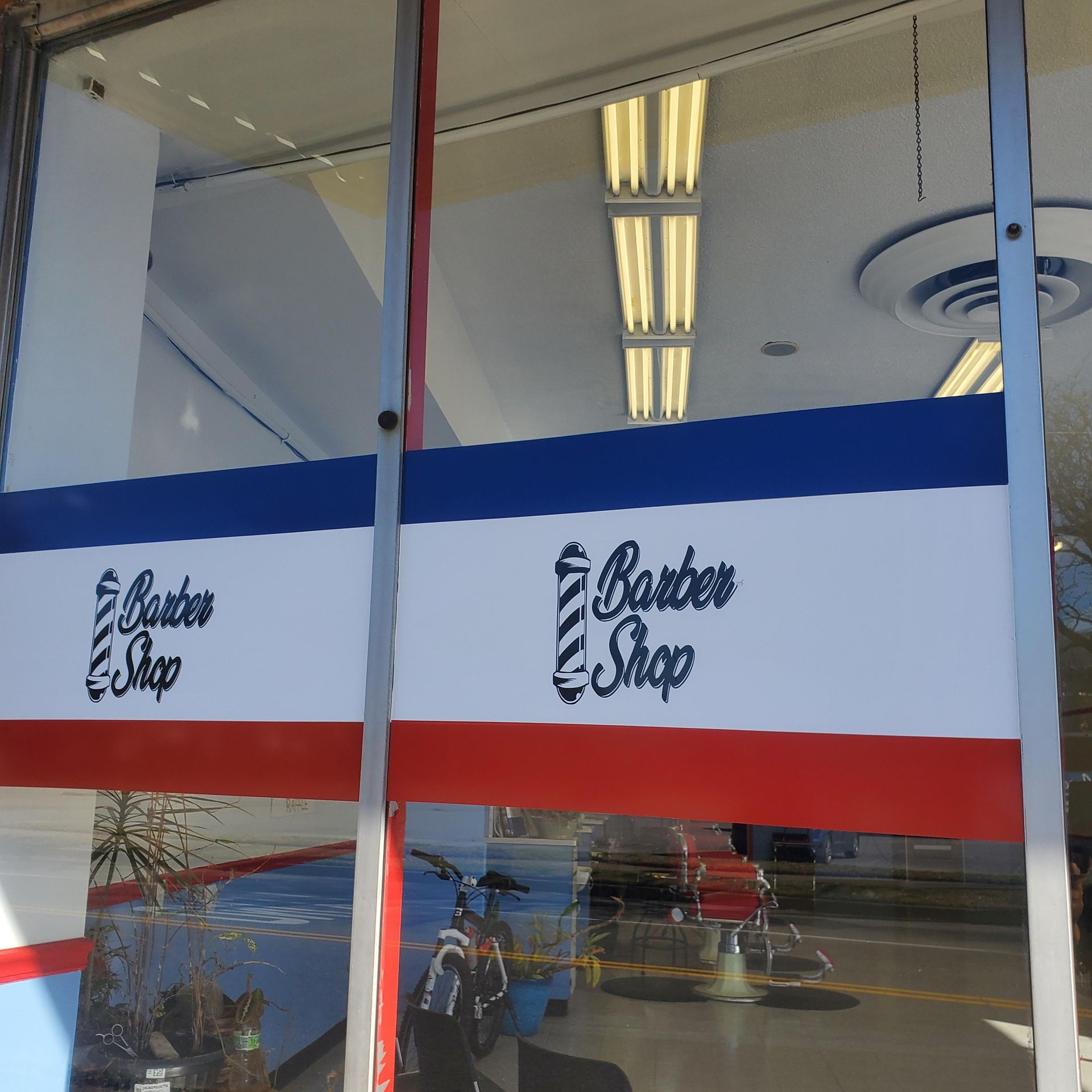 A barber shop with a red white and blue banner