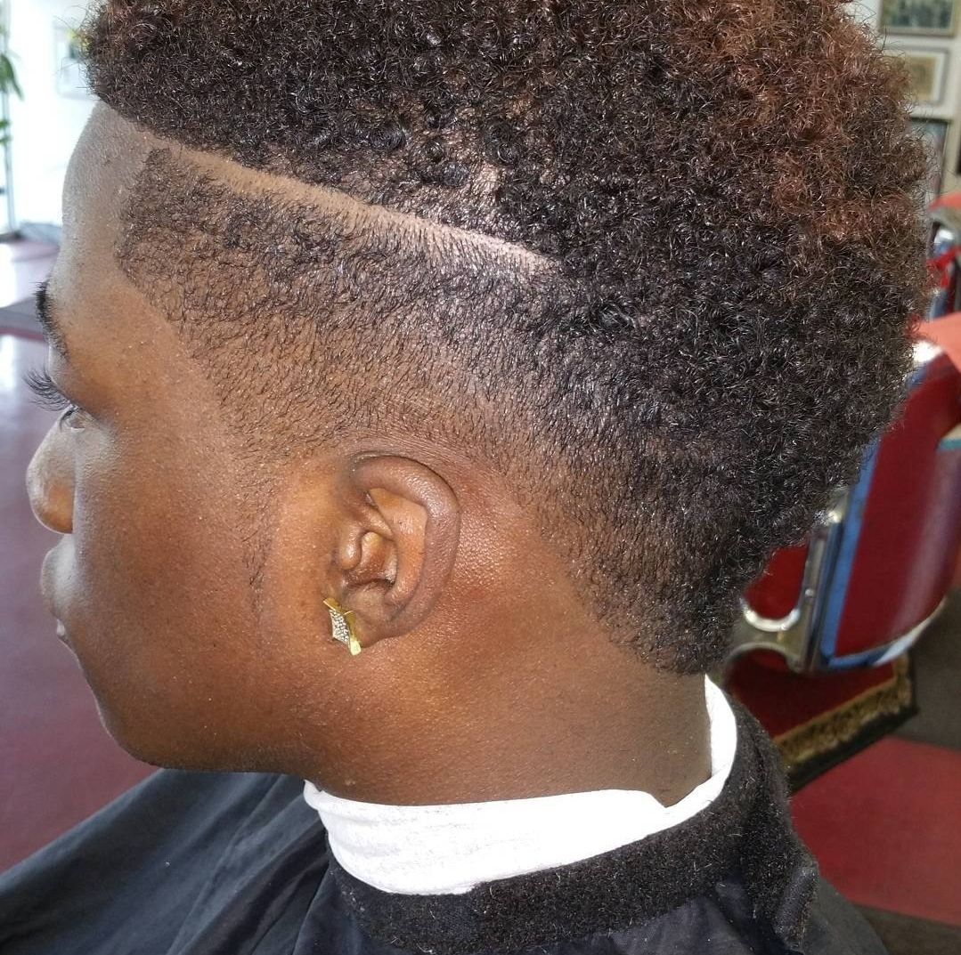 A man is getting his hair cut in a barber shop