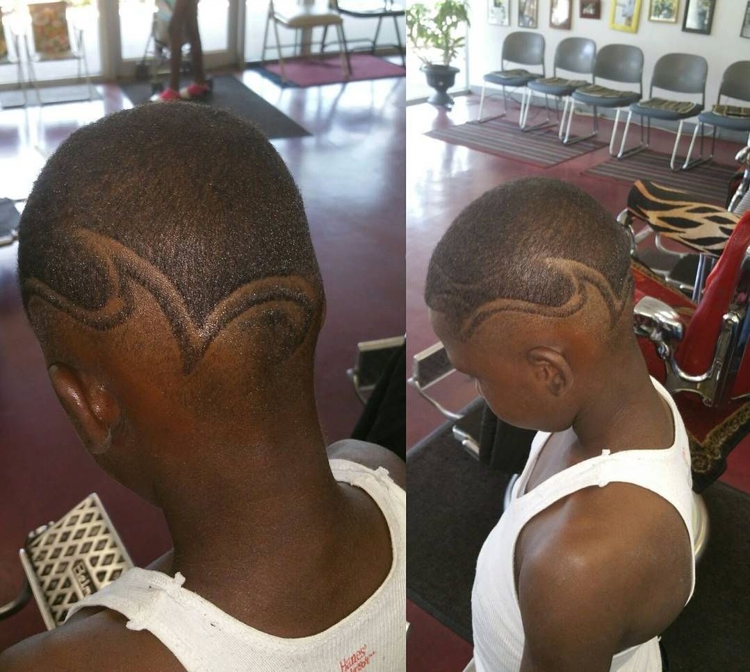 A man in a white tank top has a design in his hair