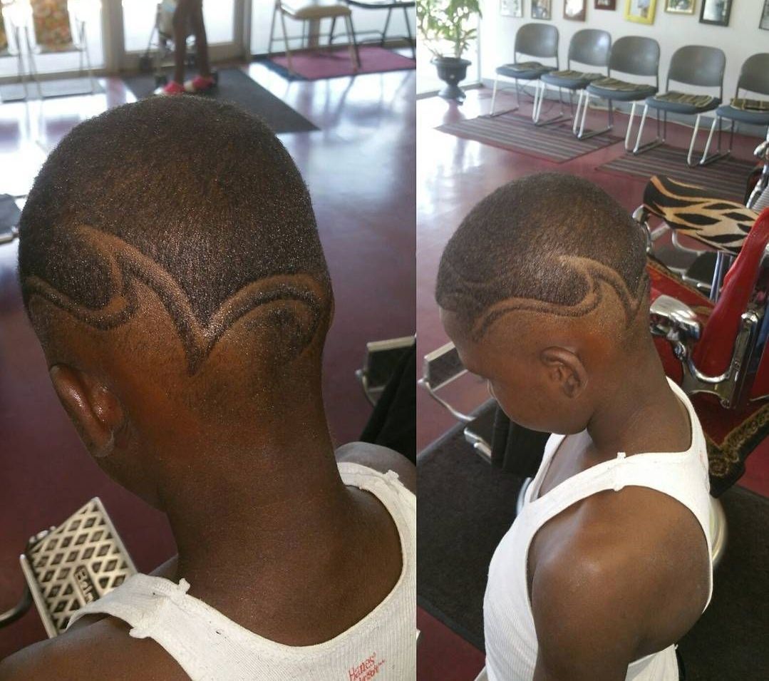 A man in a white tank top has a design in his hair