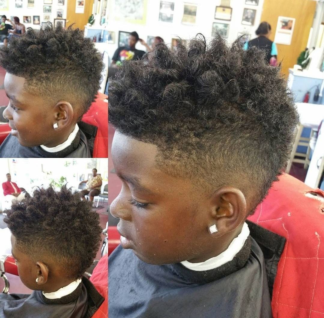 A young boy is getting his hair cut at a barber shop