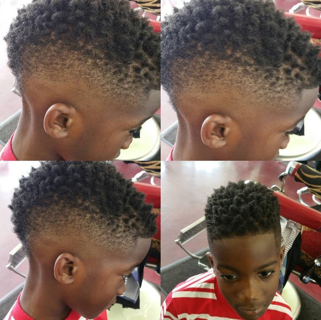 A young boy is getting his hair cut at a barber shop