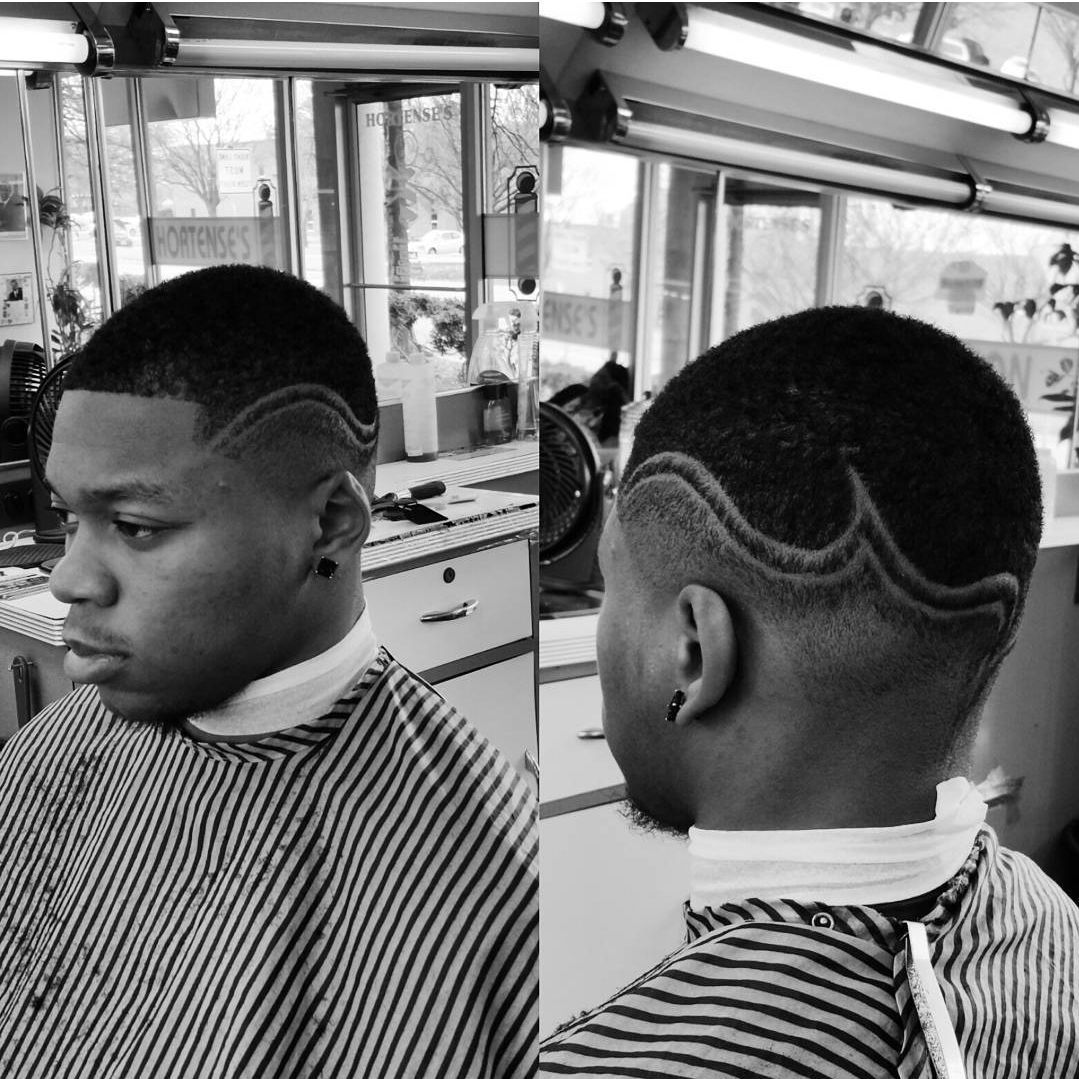 A black and white photo of a man getting his hair cut at a barber shop.