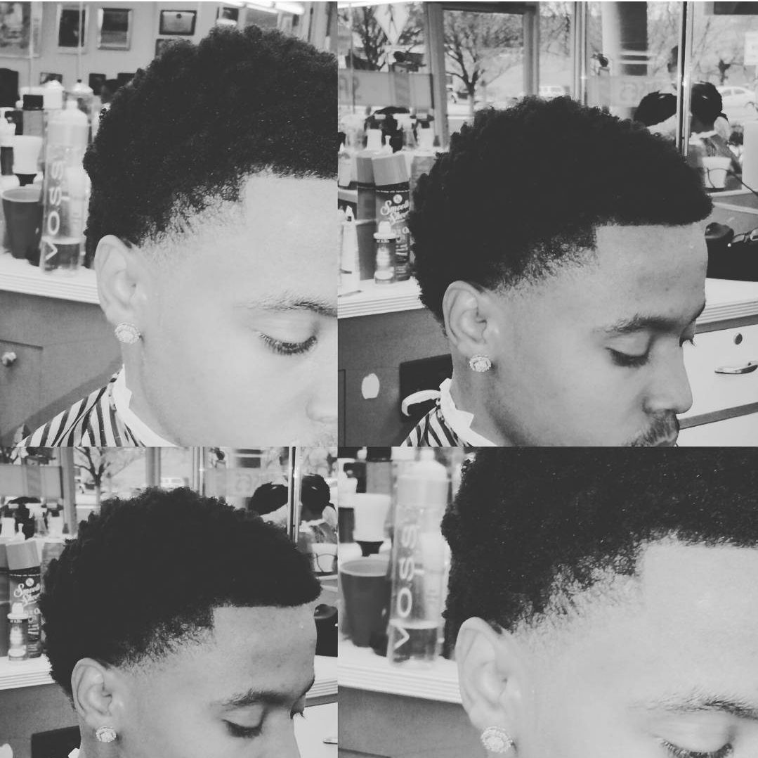 A black and white photo of a boy getting his hair cut