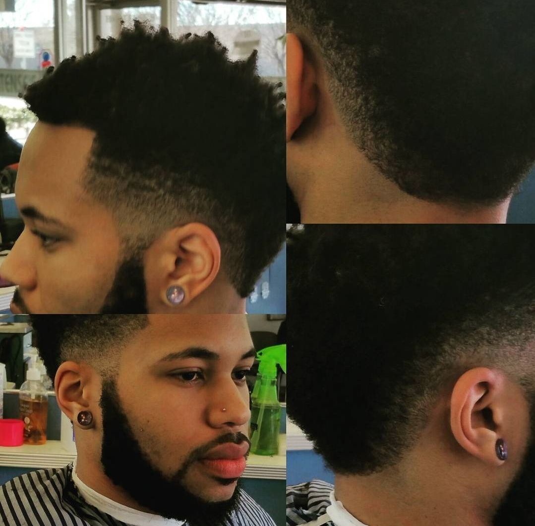 A man with a beard is getting his hair cut by a barber