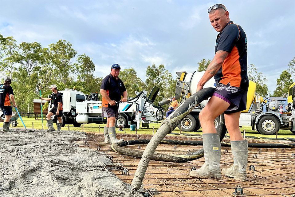 A man is pumping concrete into the ground with a hose.