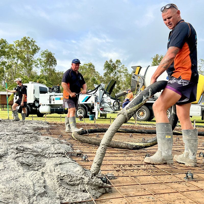 A man is pumping concrete with a hose on a construction site
