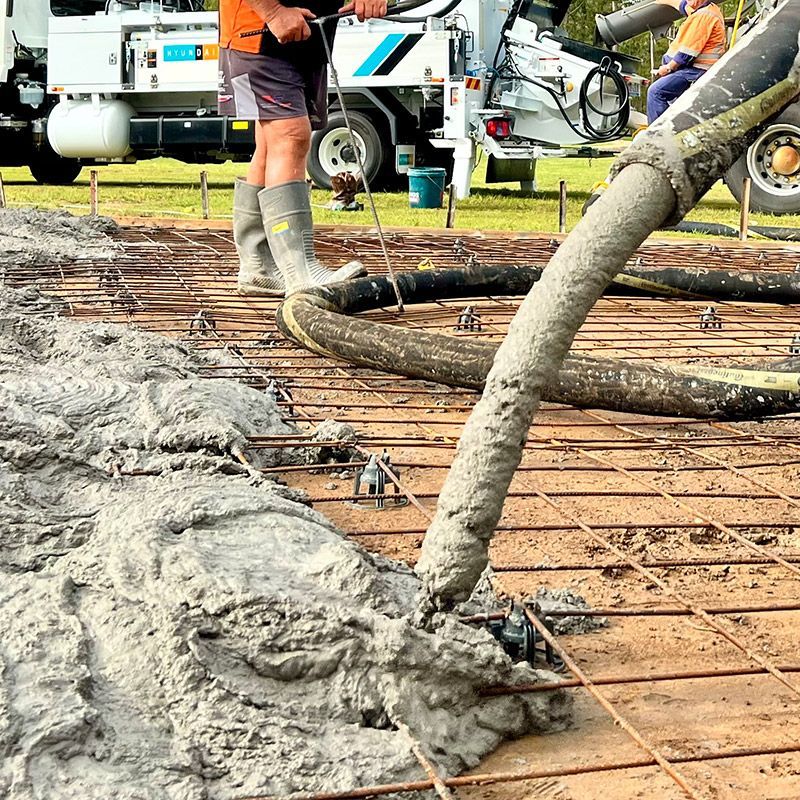 A man is pouring concrete into a concrete floor.