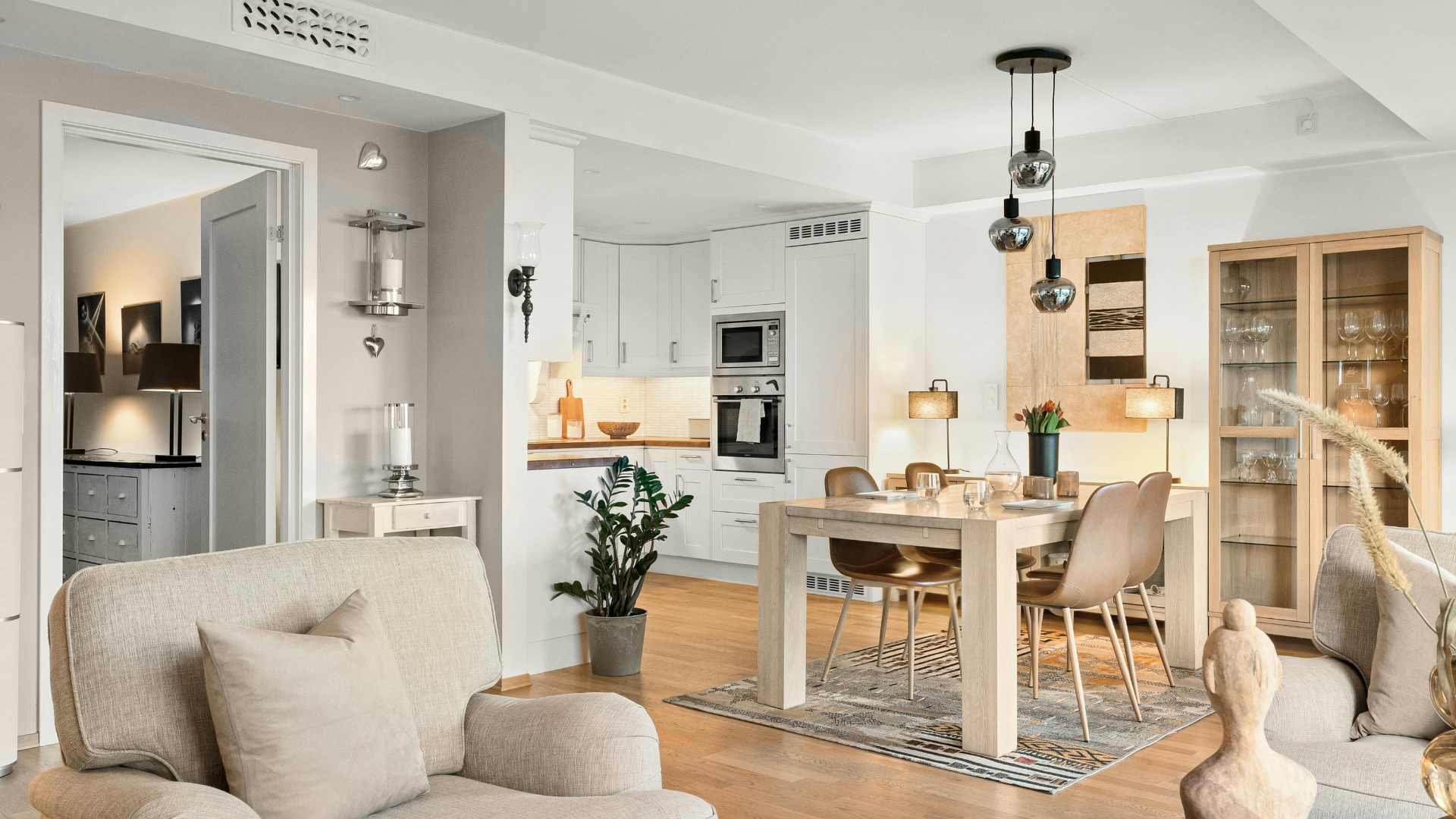 Open-concept living space with dining area, kitchen, and living room in neutral tones.