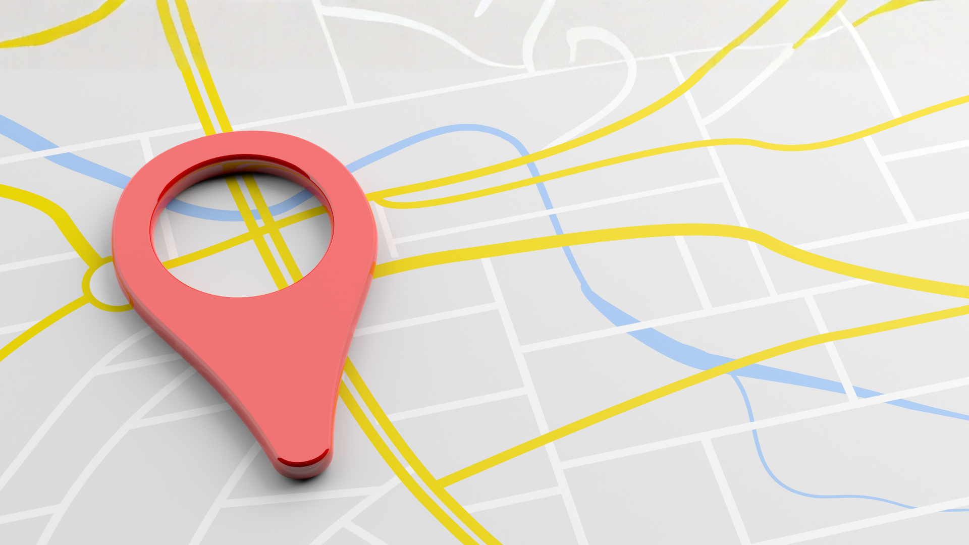 A red map pin icon sitting on top of a stylized city map with yellow streets and a light blue waterway.