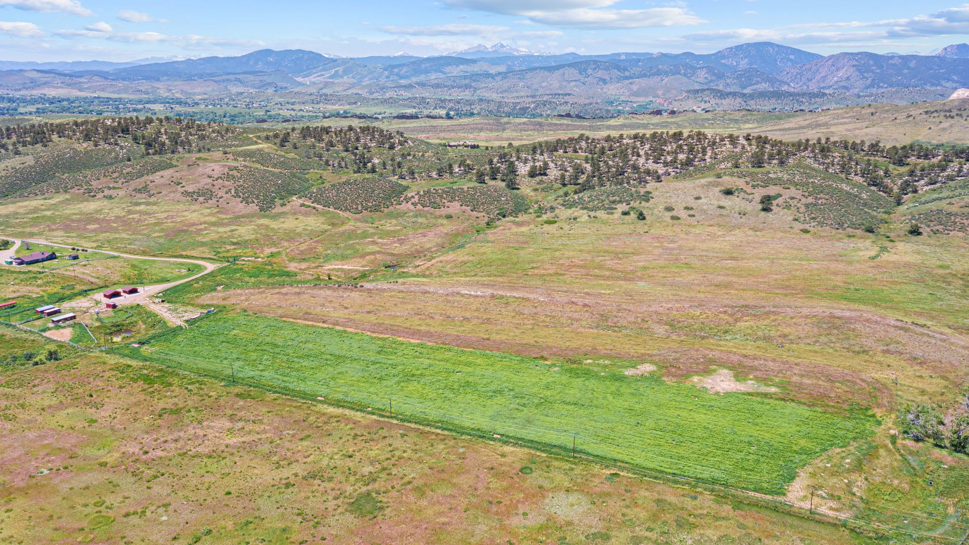 an aerial view of a field with mountains in the background