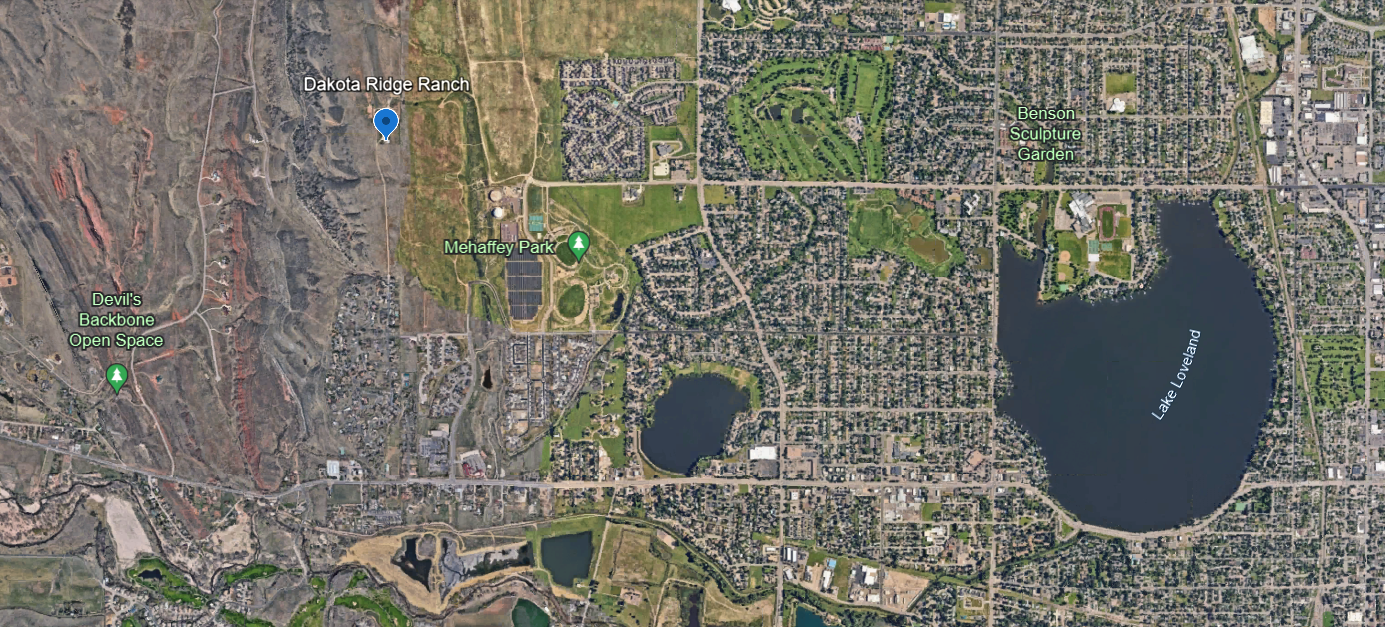 an aerial view of a farm with a cloudy sky in the background