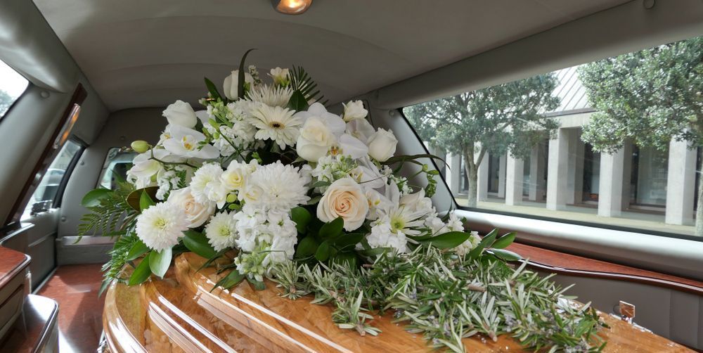 A Coffin is Sitting in the Back of a Limousine — Mid Coast Funeral and Cremation Service In Laurieton, NSW