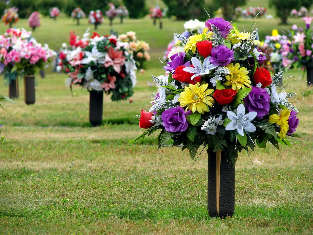 A Cemetery With Lots of Flowers in Vases in the Grass — Mid Coast Funeral and Cremation Service In Lake Cathie, NSW