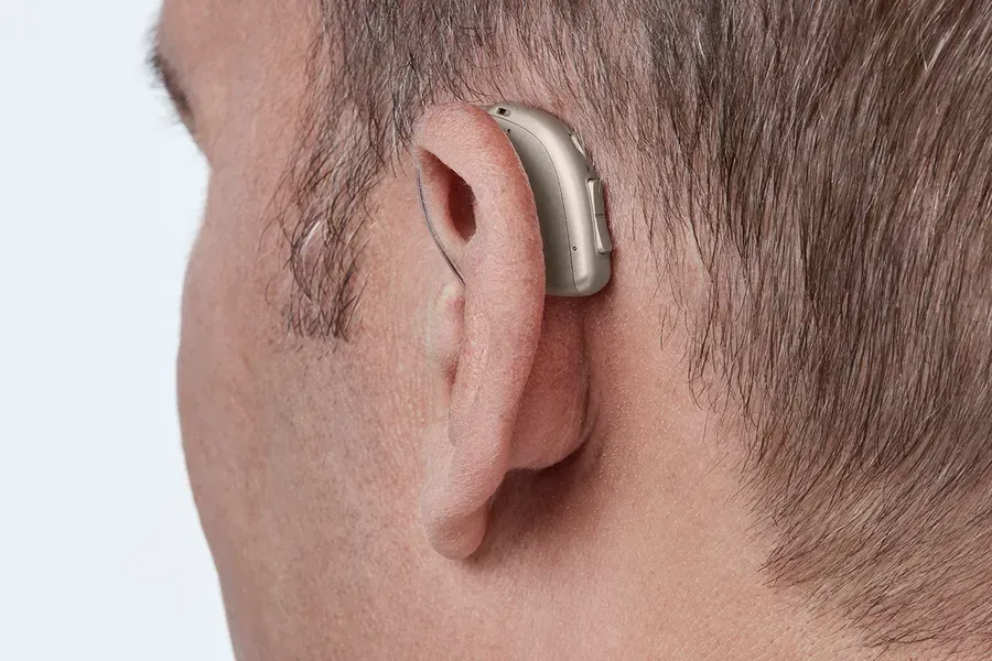 A man wearing a hearing aid in his left ear.